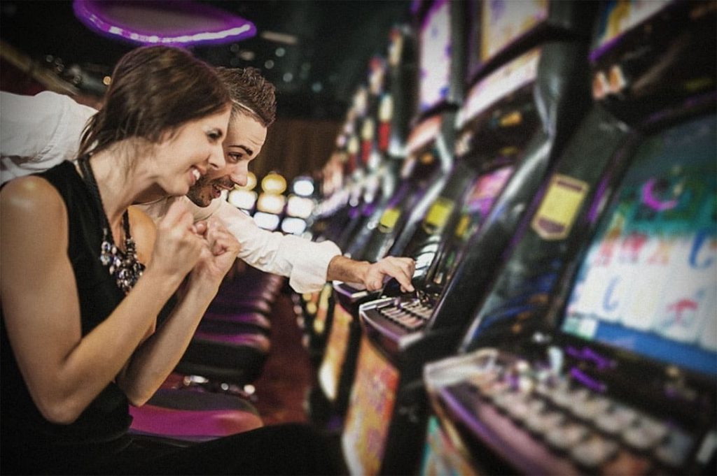 Een jongen en een meisje spelen op een gokautomaat